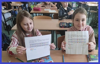 obrazek rpzedstawia dwie uczennice trzymające kartki